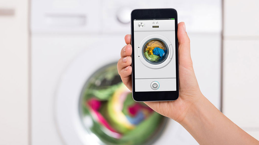 Smart washing machine running in bright utility room with digital cycle display