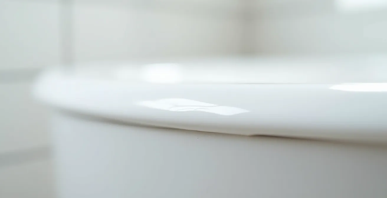 Close-up view of professional silicone caulk application on bathtub edge